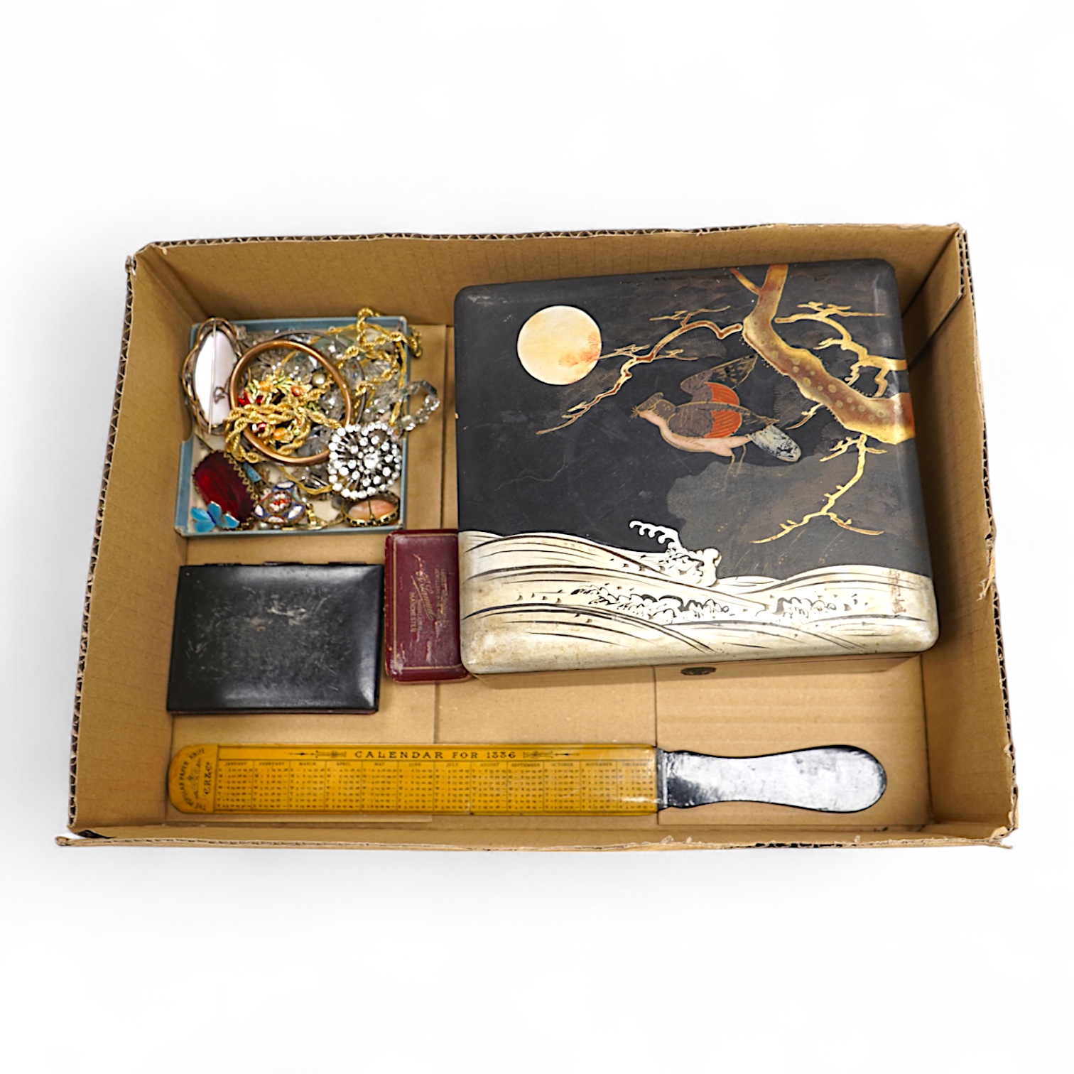 A group of costume jewellery and collector's items in a Japanese lacquer box